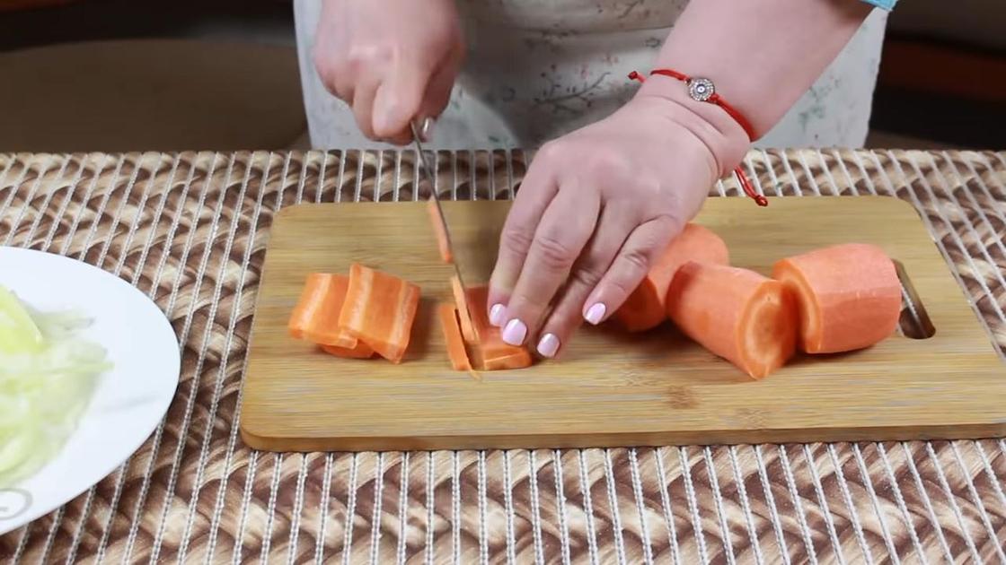 Морковь нарезают на разделочной доске