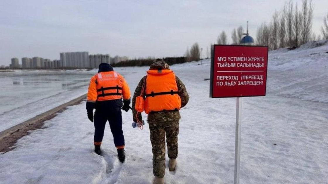 Рабочие идут по набережной реки Есиль