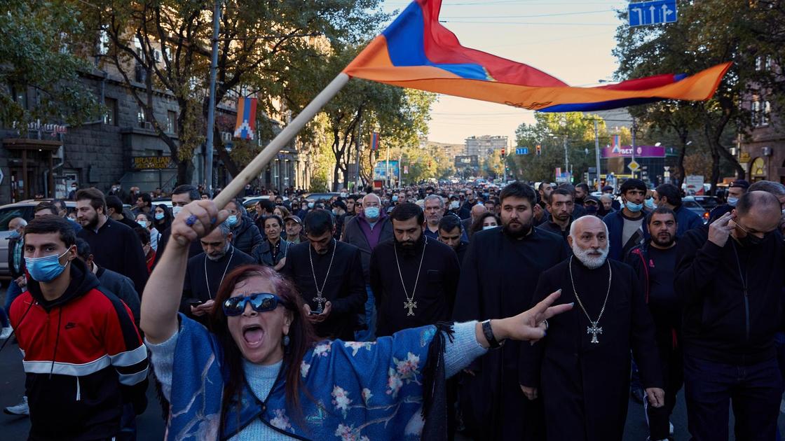 Участники акций протеста идут с флагом по улицам Еревана