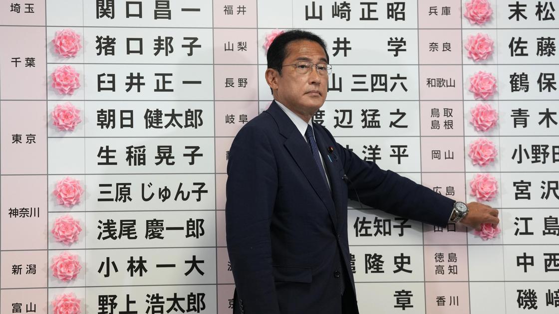 Фумио Кисида ставит розу возле имени кандидата, получившего место в верхней палате