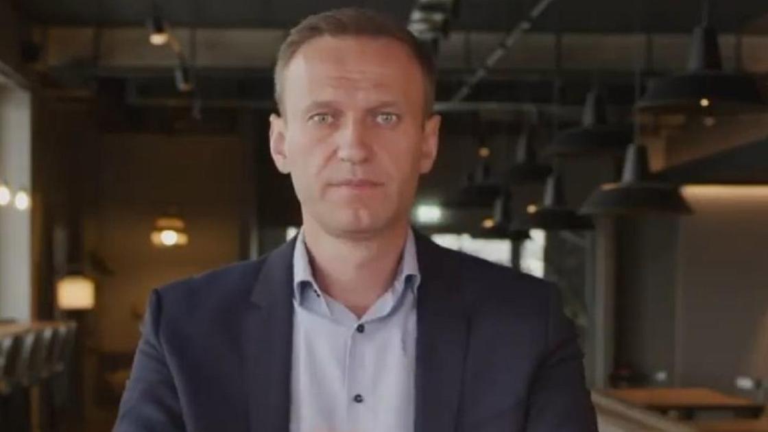 Алексей Навальный сидит за столом