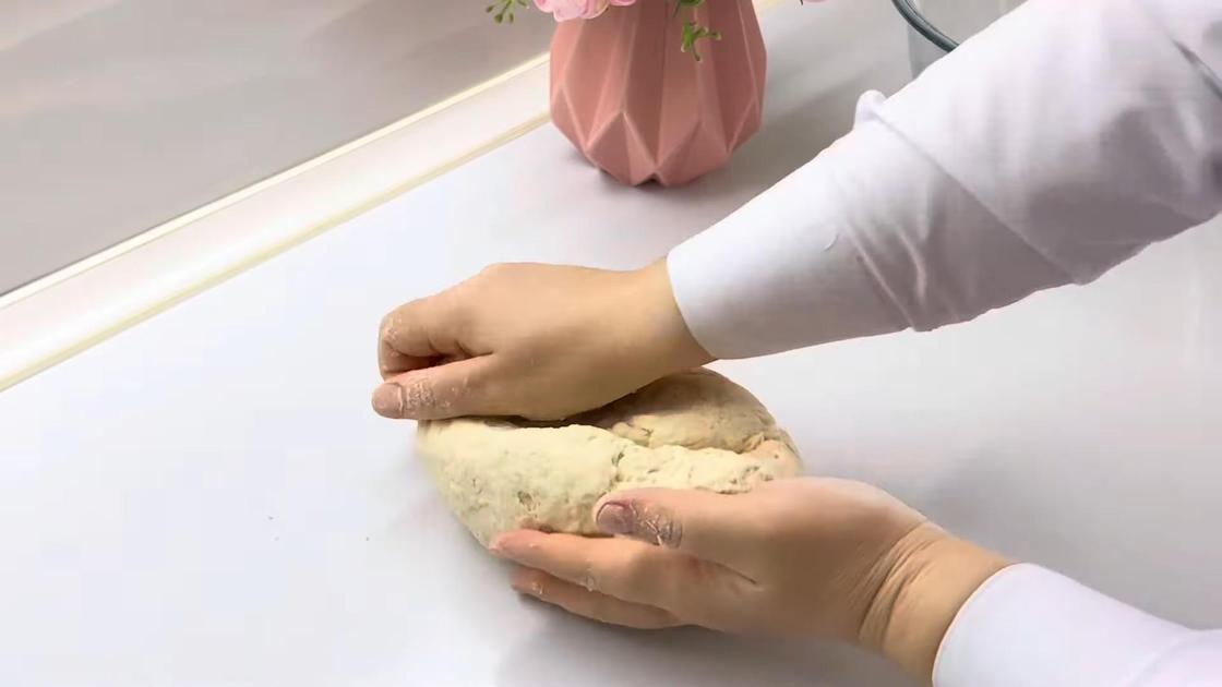 На столе руками вымешивают тесто