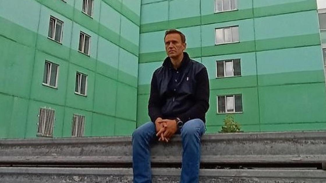 Алексей Навальный сидит на фоне многоэтажки