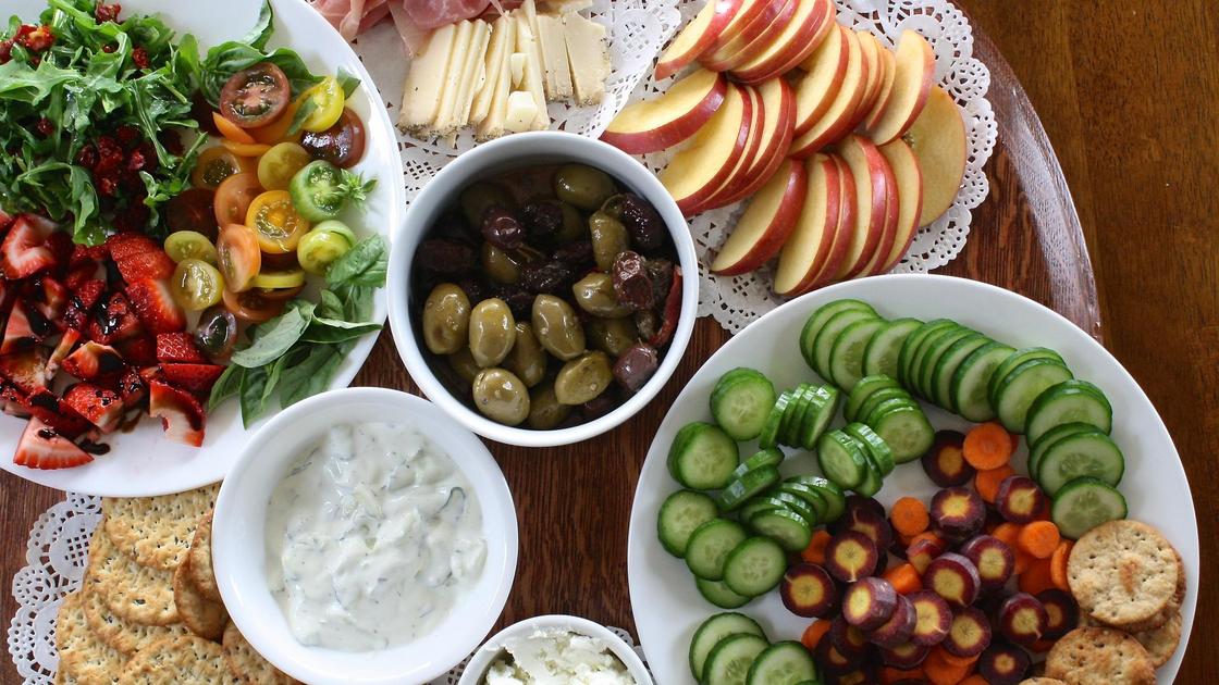 Тарелки с овощами и фруктами на столе Тарелки с овощами и фруктами на столе
