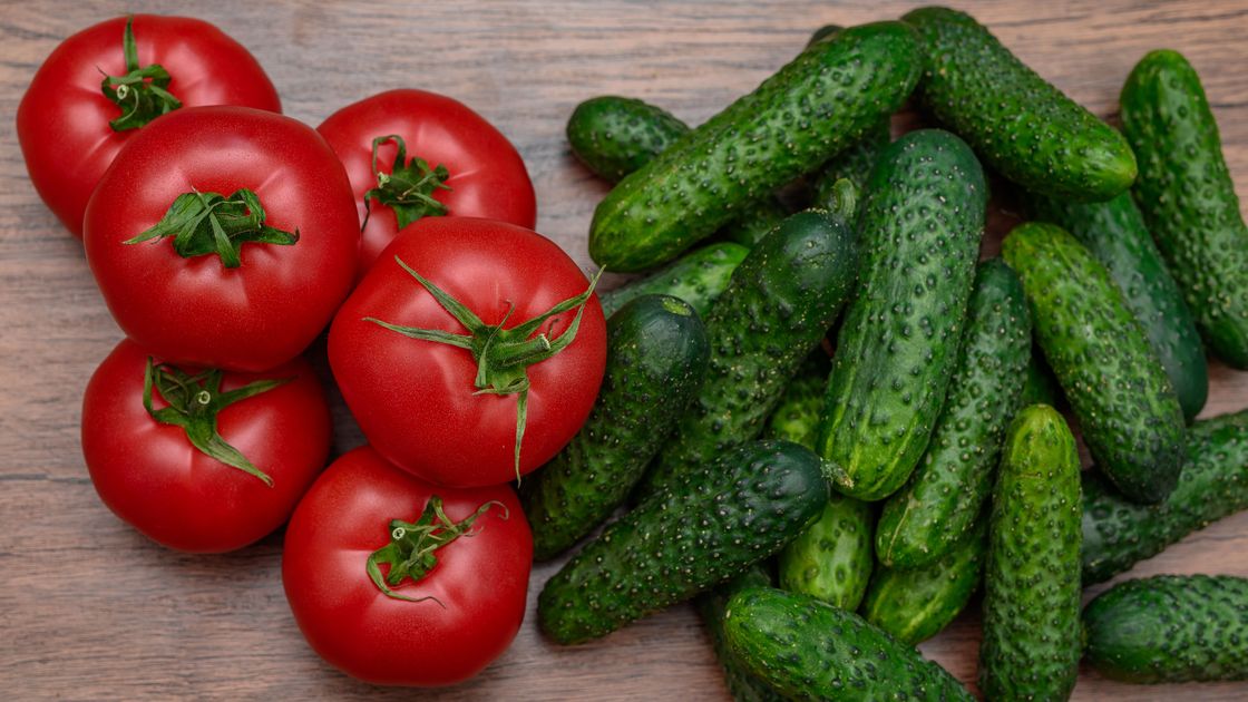 Помидоры и огурцы лежат на столе