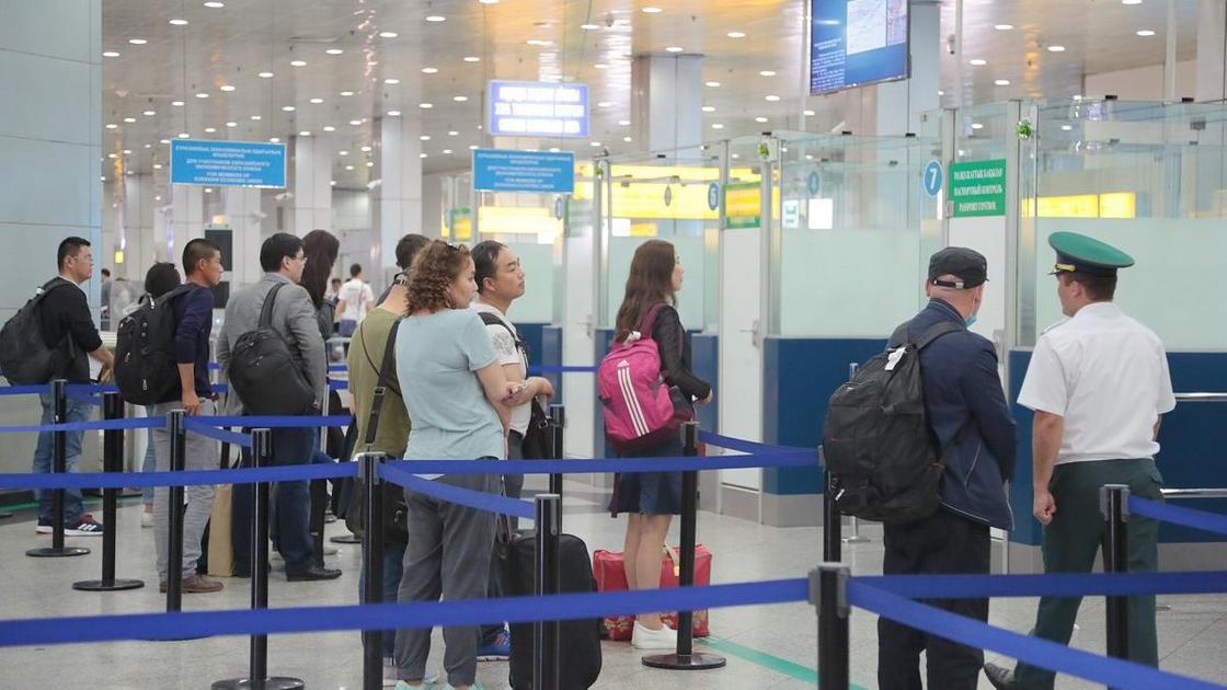 Люди стоят в очереди для прохождения паспортного контроля