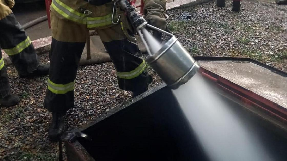 Пожарный делает проливку резервуара