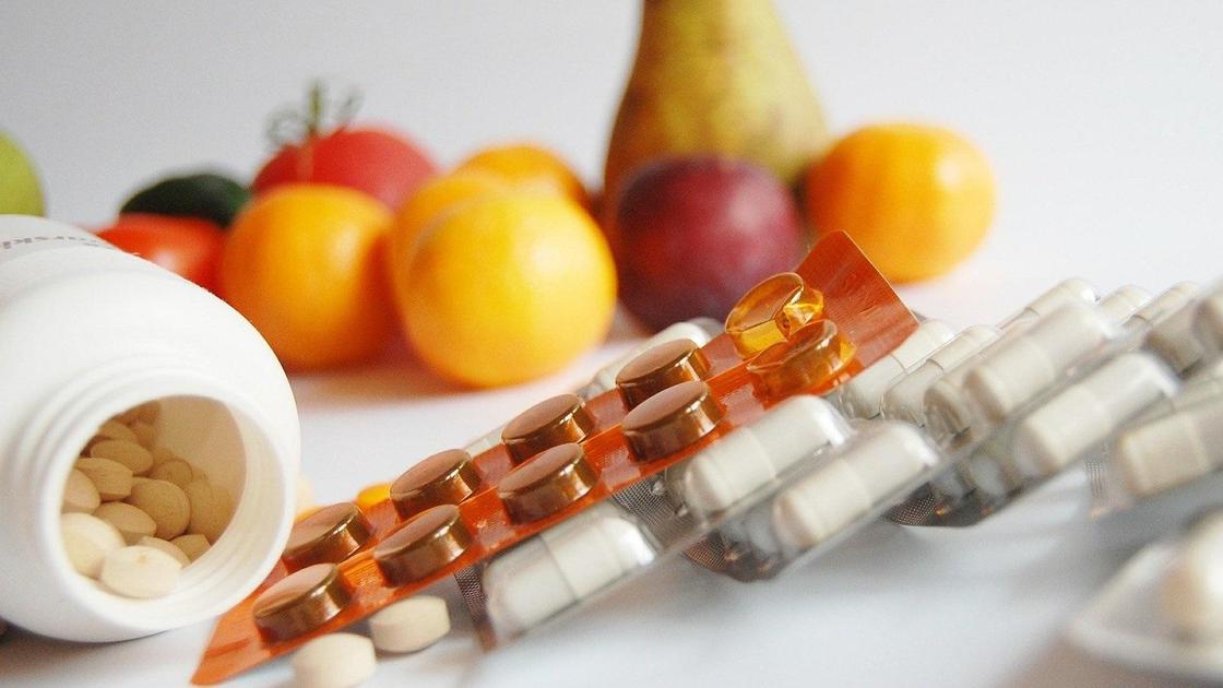 Лекарства, витамины и фрукты лежат на столе