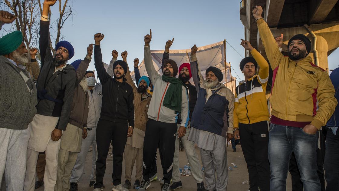 Индийцы стоят в толпе, подняв руки в воздух