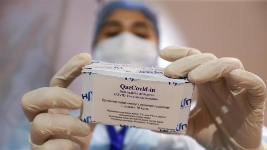 Медсестра держит в руках упаковку с вакциной QazCovid-in (торговое название - QazVac)