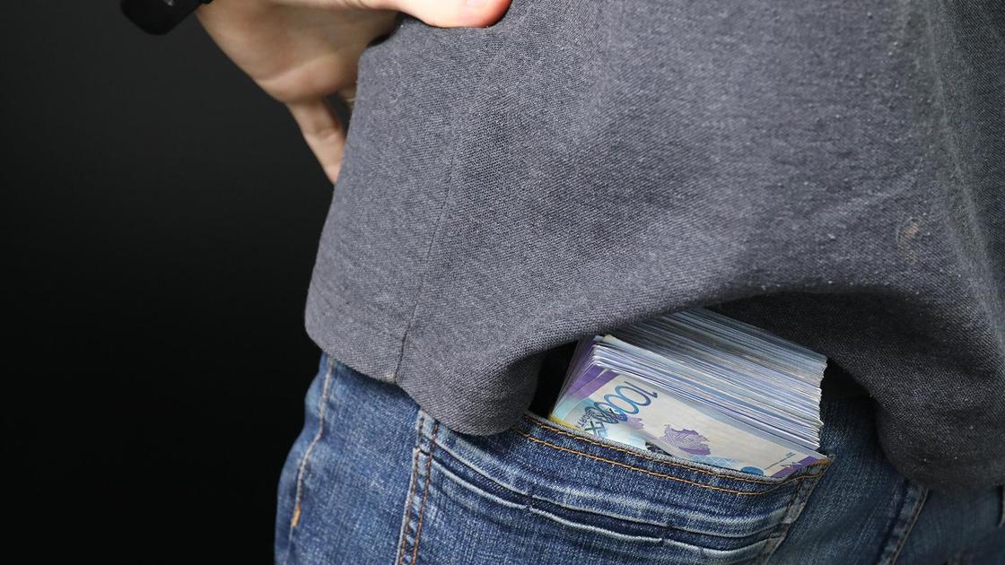 Пачка денег лежит у мужчины в заднем кармане