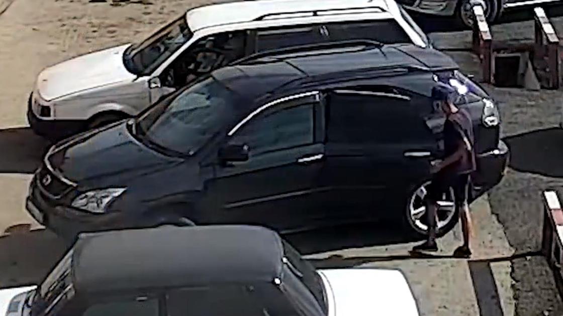 Подозреваемый достает деньги из машины