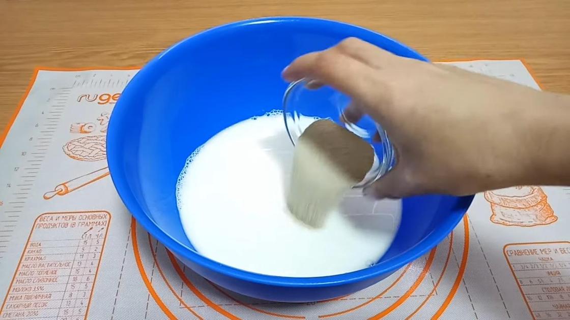 Добавление дрожжей в миску с молоком и водой