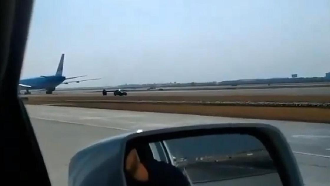 Авто едет по посадочная полоса аэропорте рядом с самолетом
