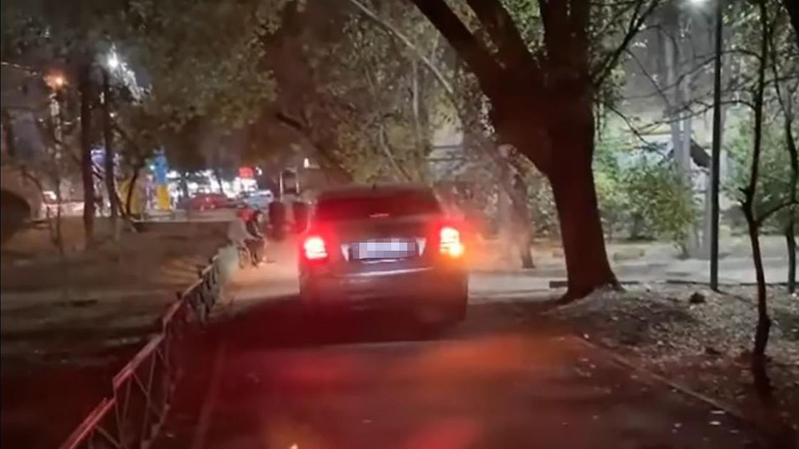 Автомобиль едет по пешеходной дороге в Алматы