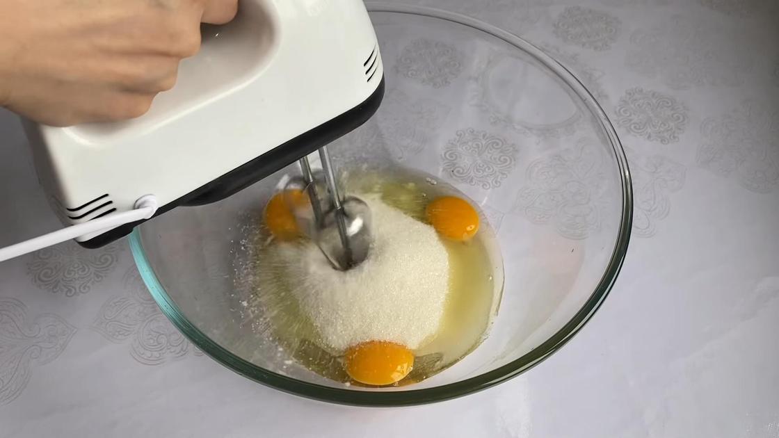 В стеклянной чаше миксером взбивают яйца с сахаром