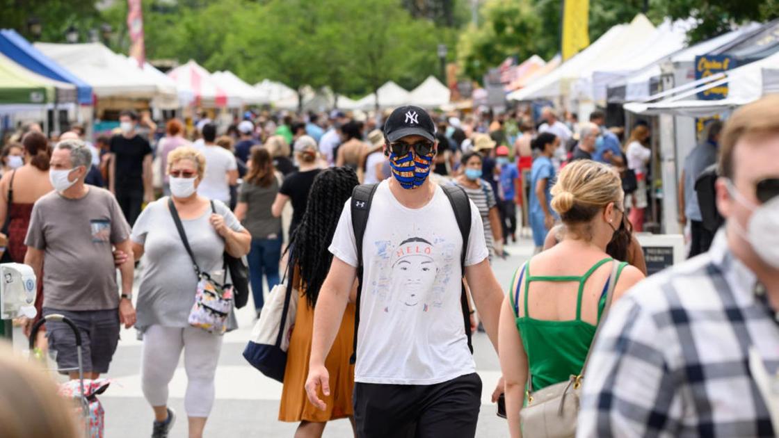 Люди в медицинских масках идут по улице