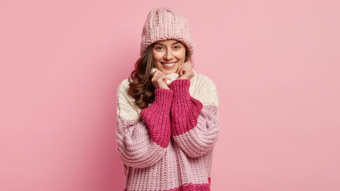 Красивый вязаный свитер и шапка на девушке