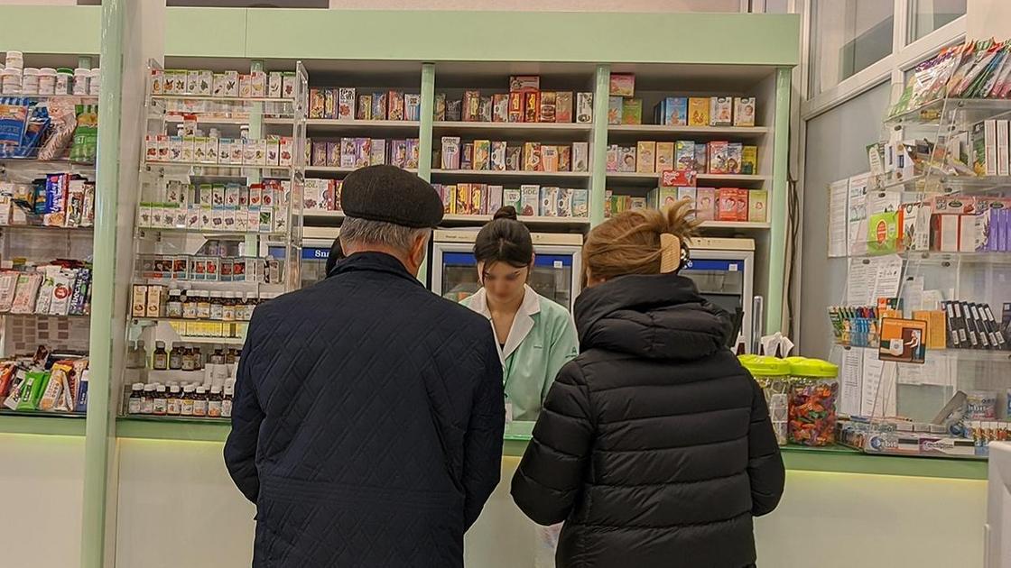 Мужчина и женщина у кассы в аптеке