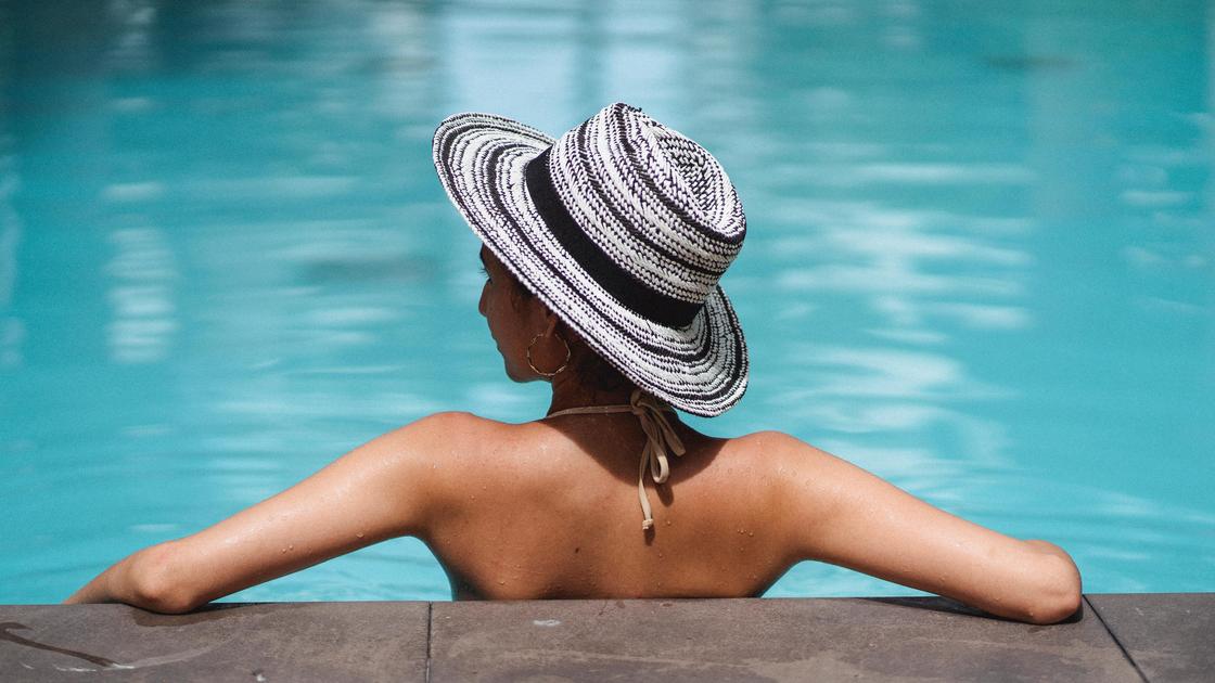 Девушка в шляпе в бассейне