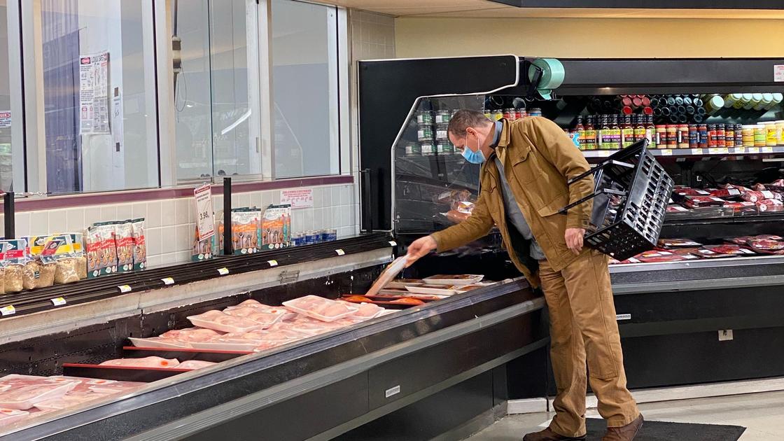 Мужчина в отделе мяса в супермаркете