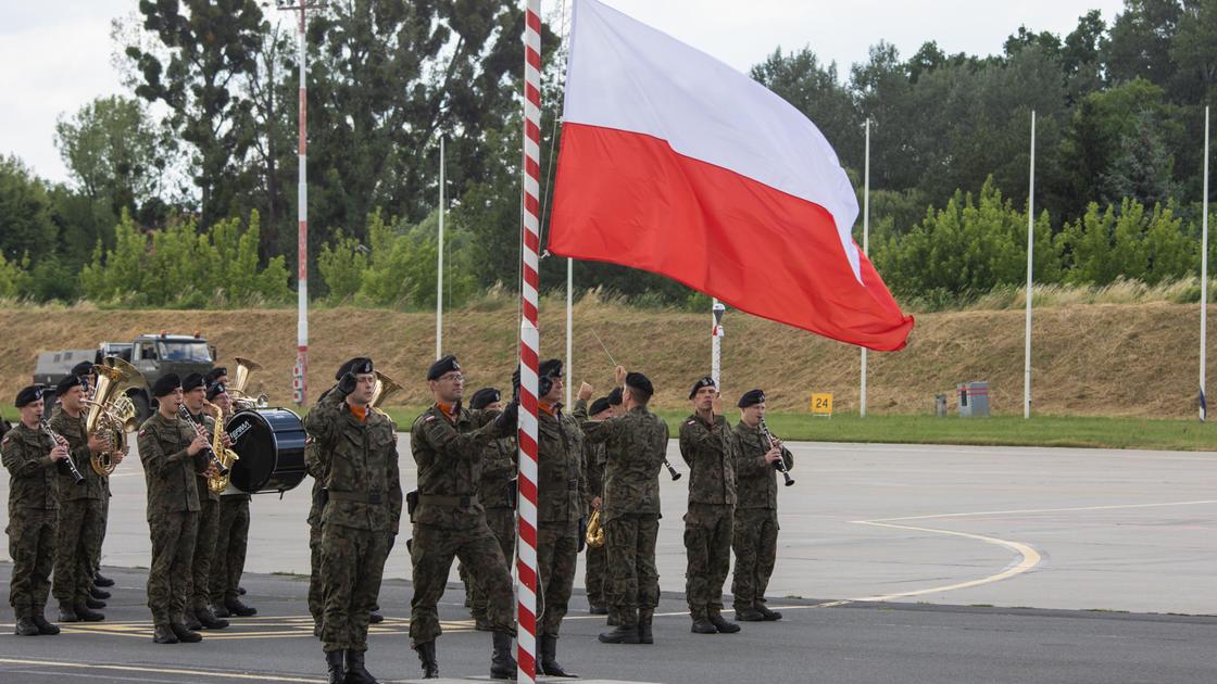 Военные рядом с флагом Польши