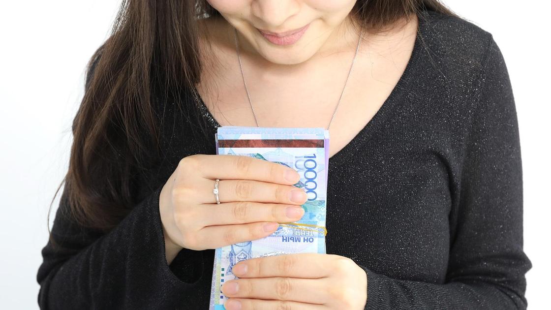 Девушка держит пачку денег