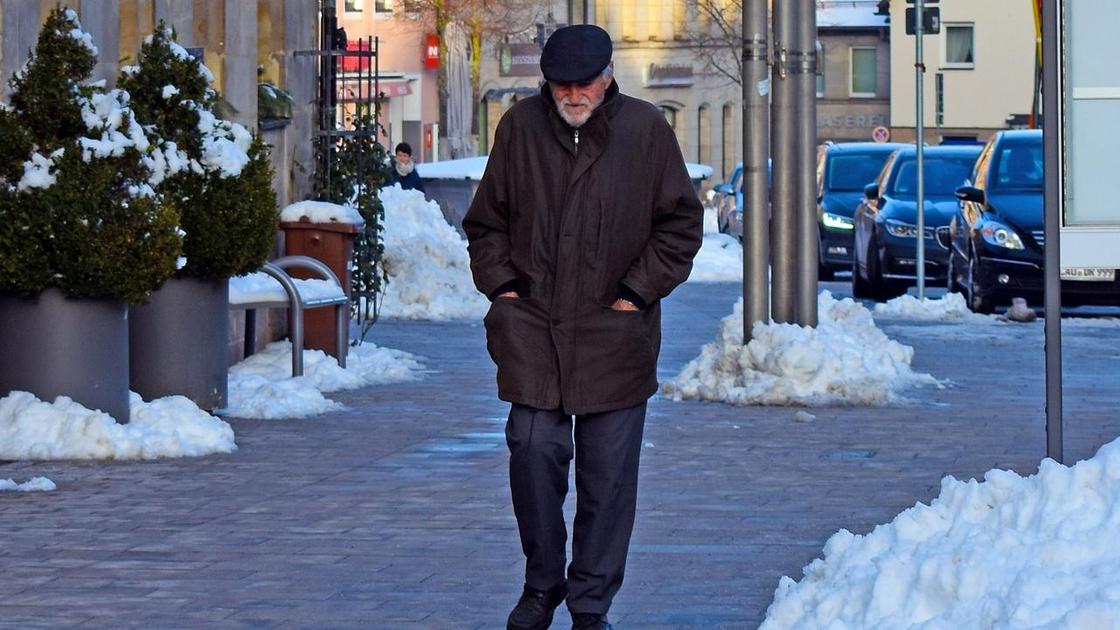 Пожилой мужчина идет по улице