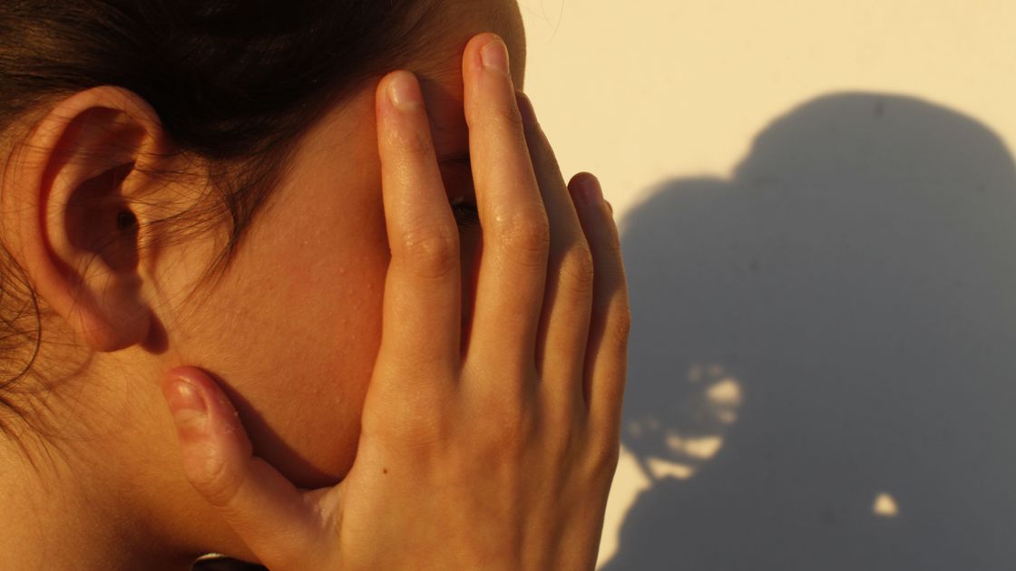 Девочка прикрывает лицо руками