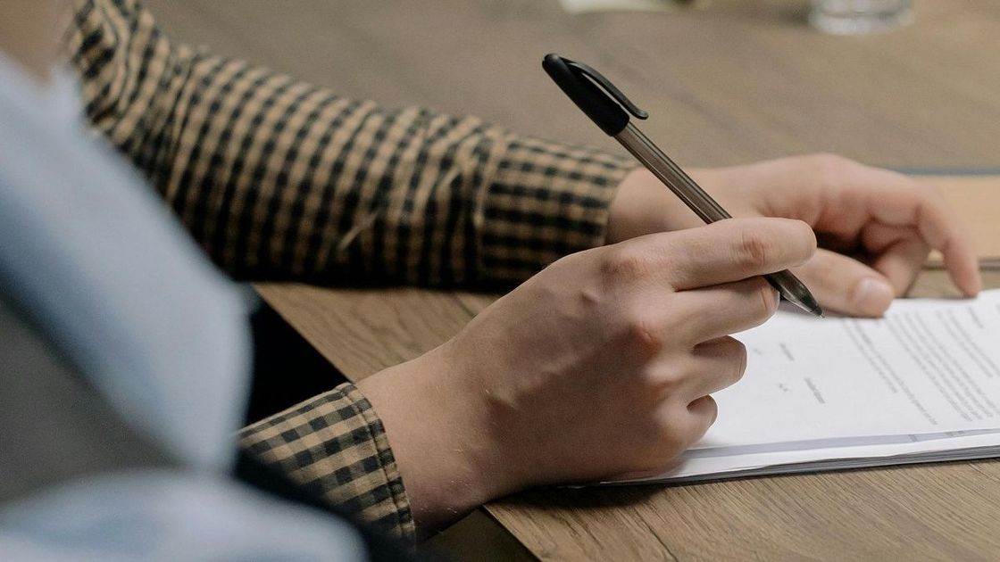 Мужчина подписывает документ