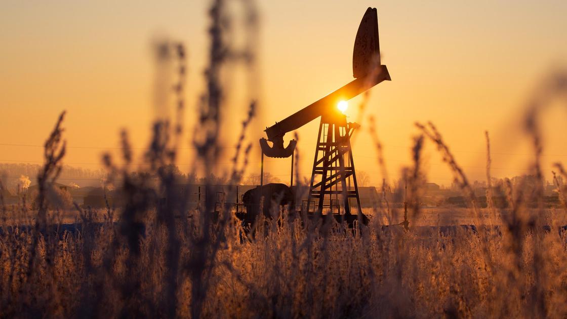 Нефтяная вышка работает посреди поля