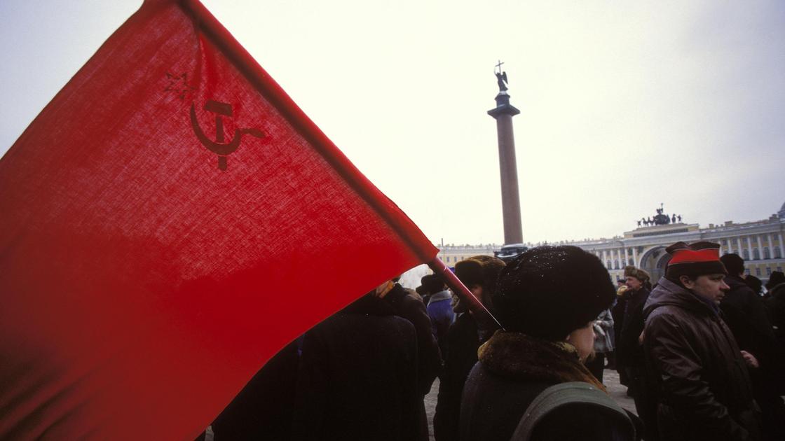 Женщина с флагом СССР идет по площади
