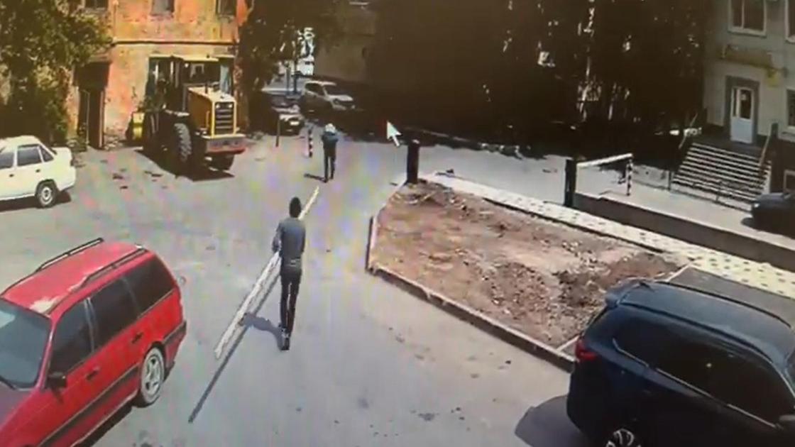 Мужчина несет по улице стрелу от шлагбаума Мужчина несет по улице стрелу от шлагбаума