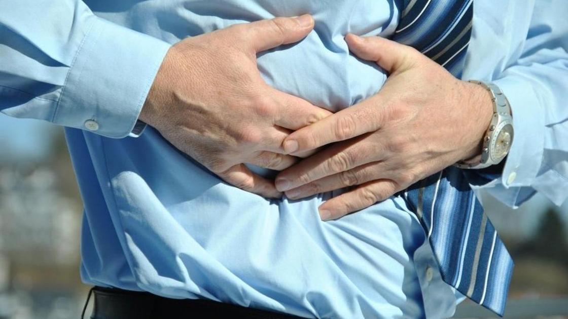 мужчина держится за живот мужчина держится за живот