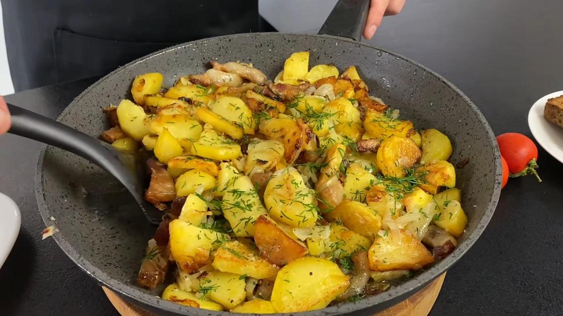 Картофель в сковороде посыпают свежим укропом