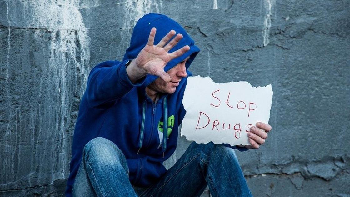 Мужчина держит табличку с надписью Stop Drugs