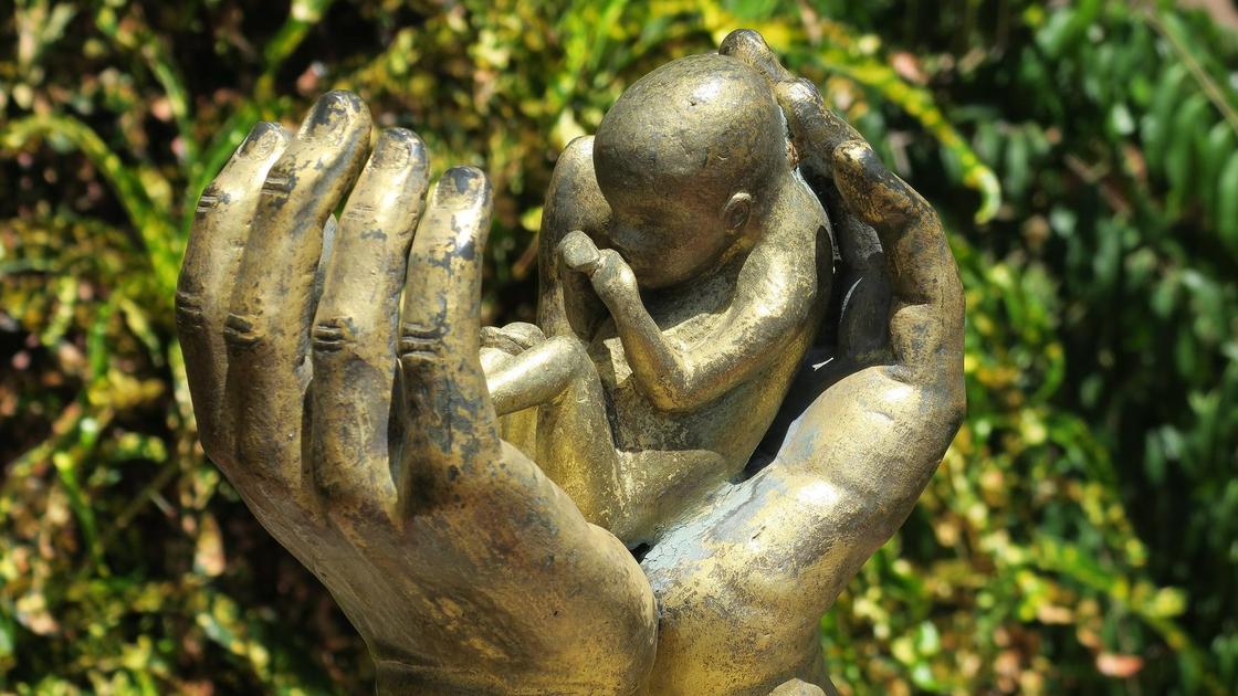 Статуя рук, держащих младенца