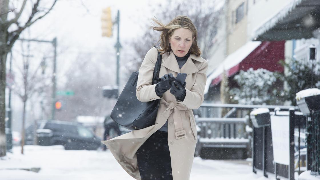 Женщина идет по улице зимой