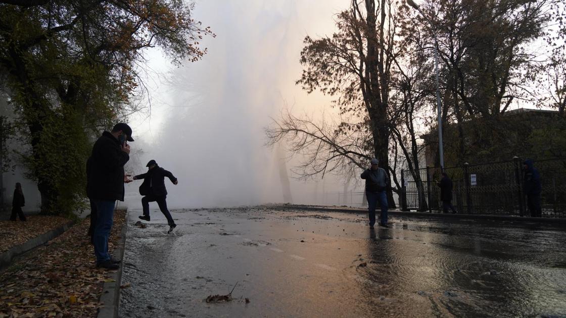 Люди на месте прорыва трубы в Алматы