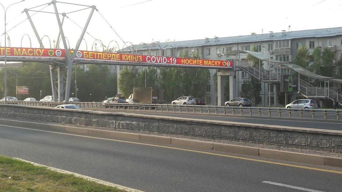 надпись "носите маску" на пешеходном мосту