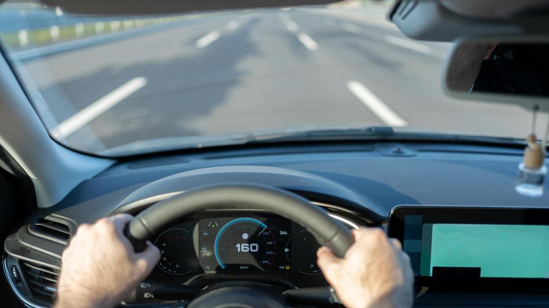 Мужчина за рулем быстро едет на автомобиле