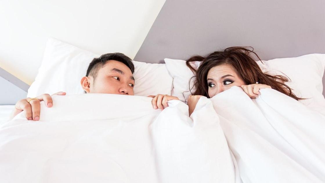 Пара в постели укрылась одеялом