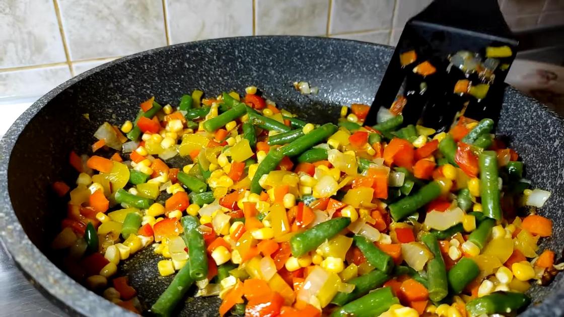 Перец, лук, морковь, зеленая спаржевая фасоль и кукуруза на сковороде
