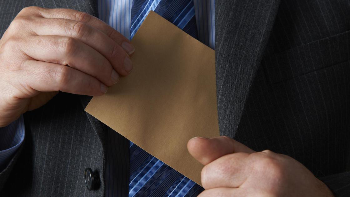 Мужчина убирает конверт