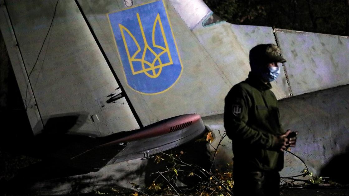 Военнослужащий на фоне упавшего самолета с гербом Украины