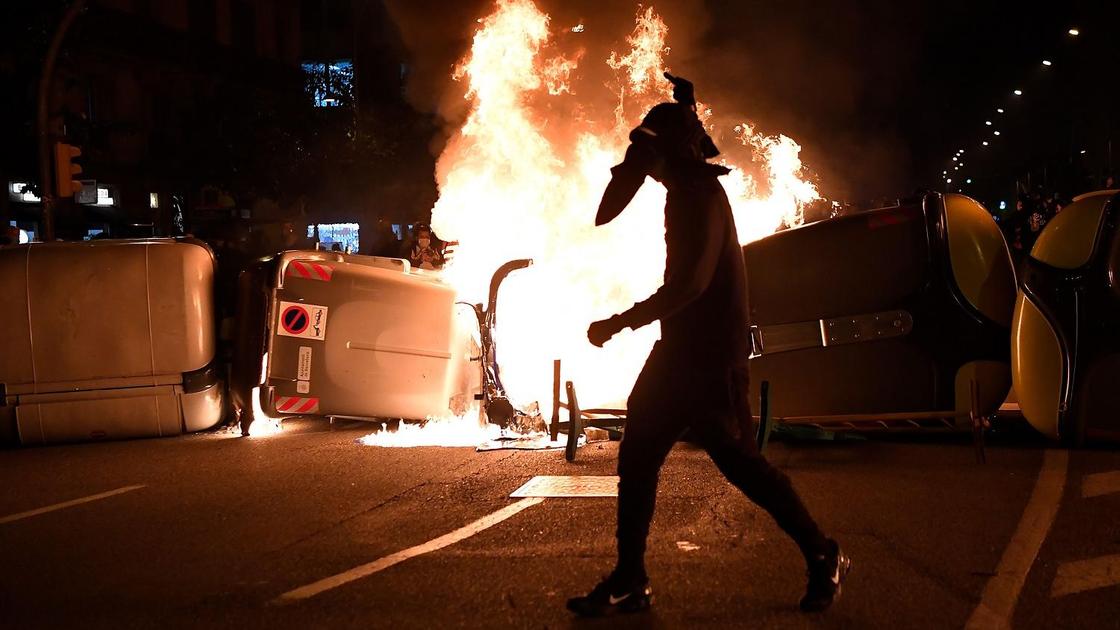 Протестующий на фоне горящего авто