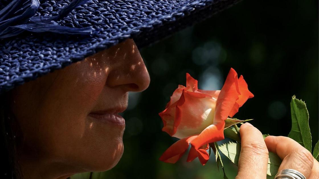Женщина нюхает цветок