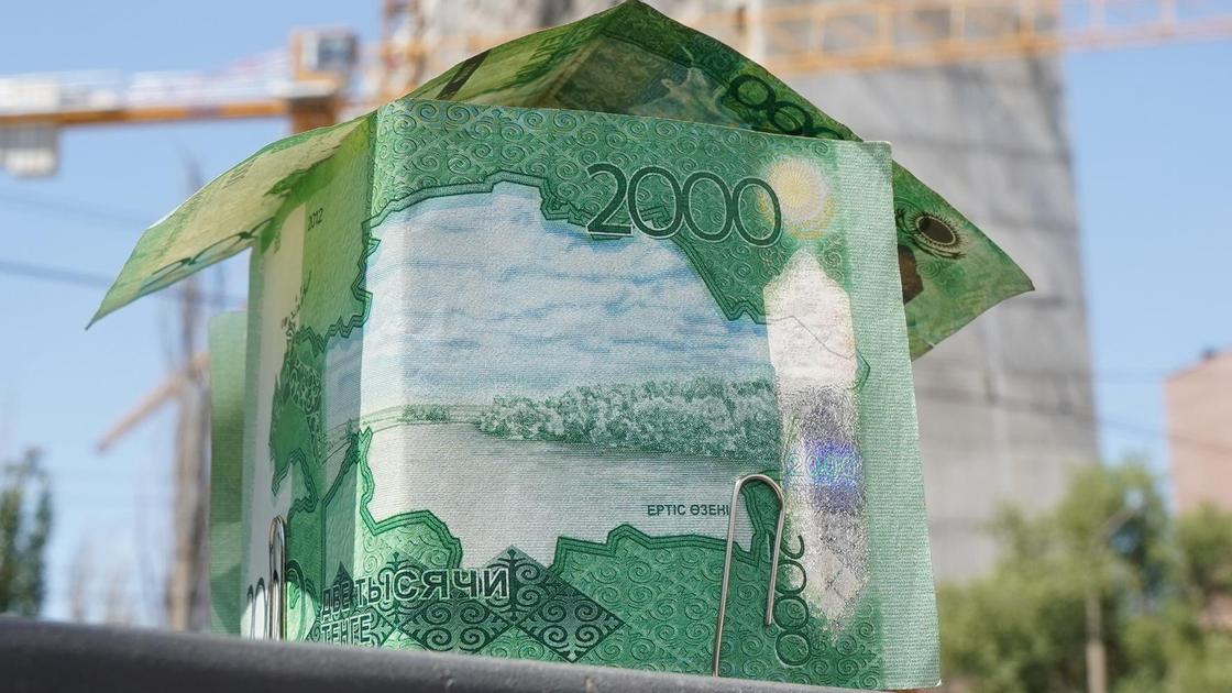 Деньги на фоне строящегося дома.