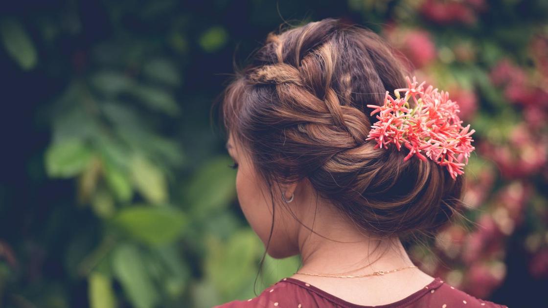 Девушка с красивой прической, украшенной объемной косой и цветком