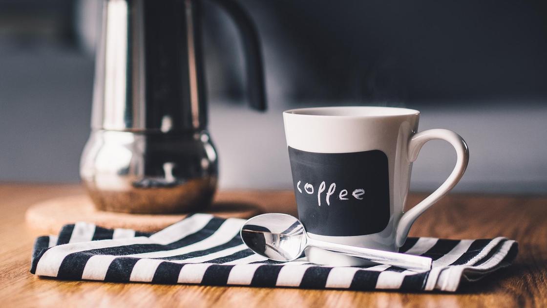 Кофейник и чашка кофе на столе